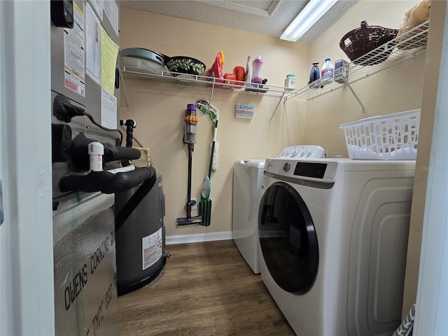 laundry area with washing machine and clothes dryer, a textured ceiling, and hardwood / wood-style flooring