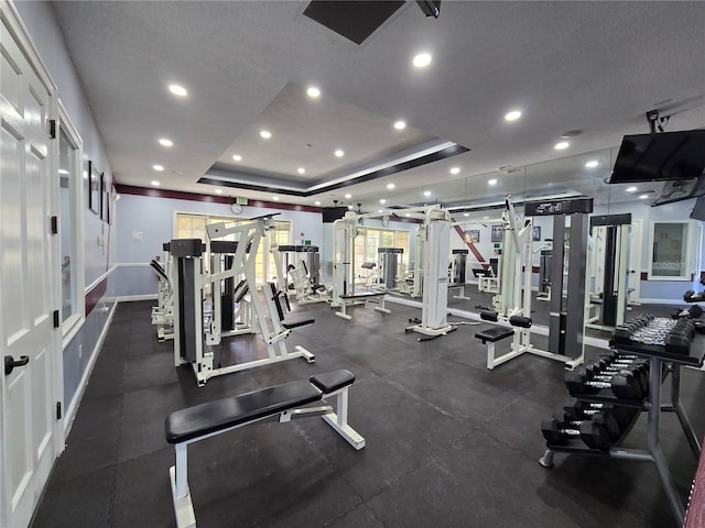 exercise room featuring a raised ceiling