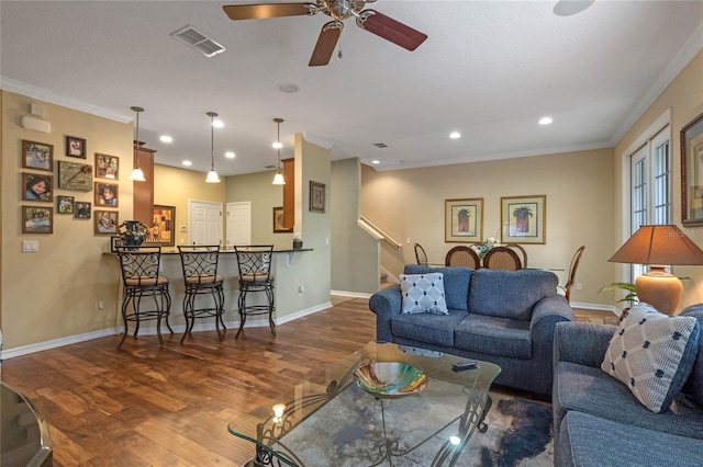 living room with ceiling fan, dark hardwood / wood-style flooring, and ornamental molding