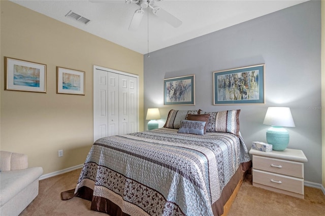 bedroom with ceiling fan, light carpet, and a closet