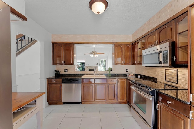 kitchen with ceiling fan, tasteful backsplash, sink, light tile patterned flooring, and appliances with stainless steel finishes