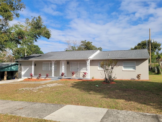 ranch-style home featuring covered porch and a front yard