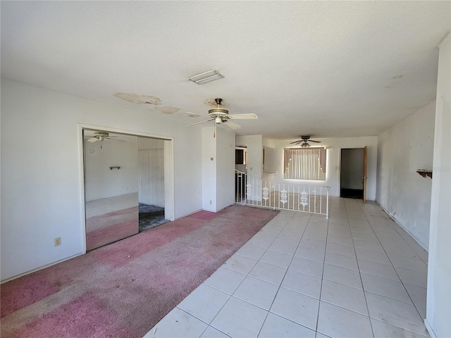 unfurnished living room featuring light colored carpet and a textured ceiling