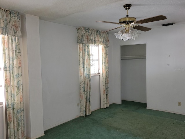 unfurnished bedroom with ceiling fan, light colored carpet, a textured ceiling, and a closet