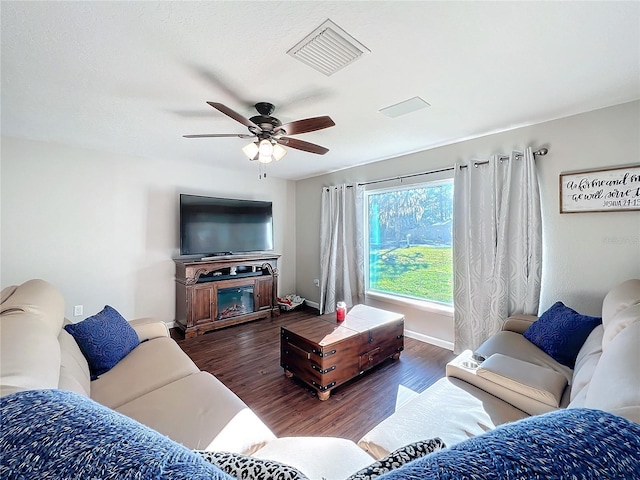 living room with ceiling fan and dark wood-type flooring