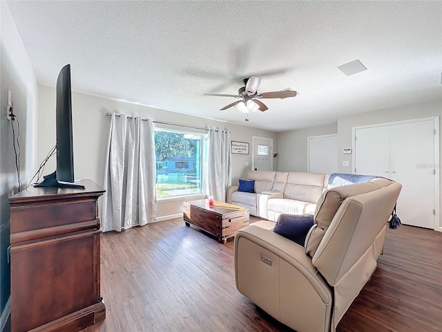 living room featuring hardwood / wood-style floors, ceiling fan, and a textured ceiling