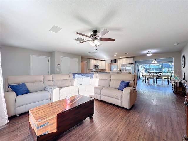 living room with a textured ceiling and dark hardwood / wood-style floors