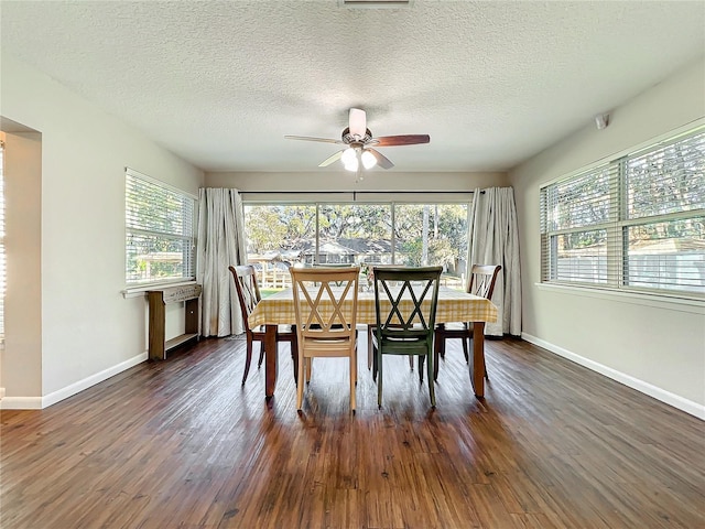 dining space with ceiling fan, dark hardwood / wood-style flooring, and a textured ceiling