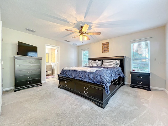 carpeted bedroom featuring ensuite bath and ceiling fan