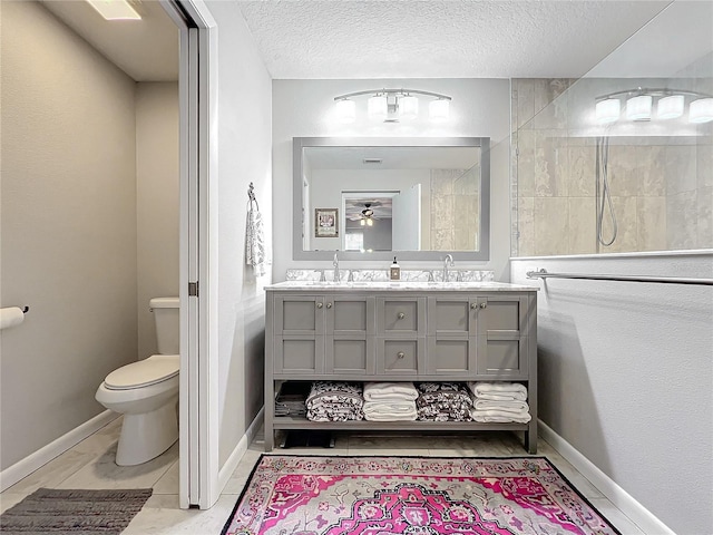 bathroom with a textured ceiling, vanity, and toilet