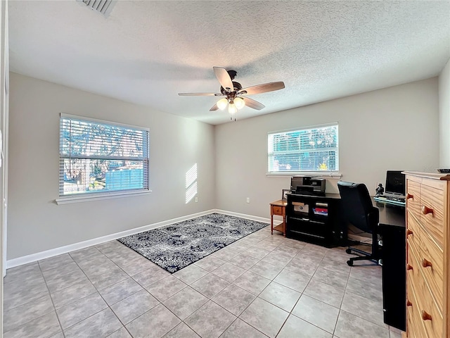 tiled office space featuring ceiling fan and a textured ceiling