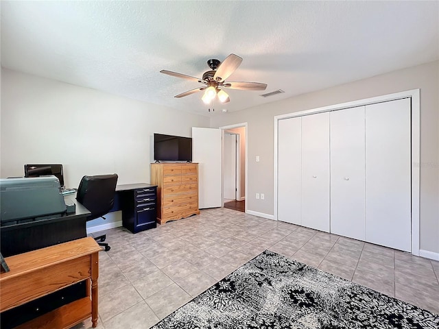 home office with ceiling fan, light tile patterned flooring, and a textured ceiling