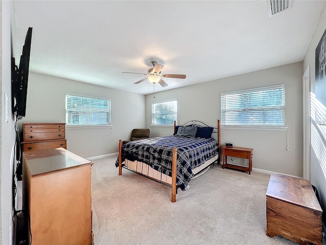 carpeted bedroom with multiple windows and ceiling fan