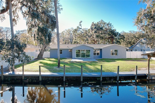 back of house with a yard and a water view