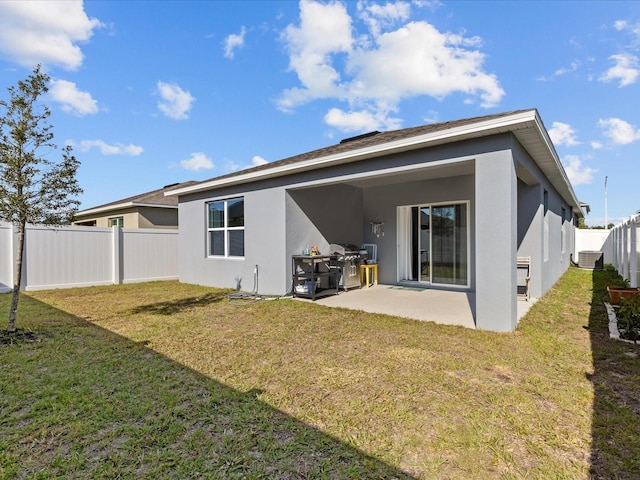 back of house featuring a patio and a lawn