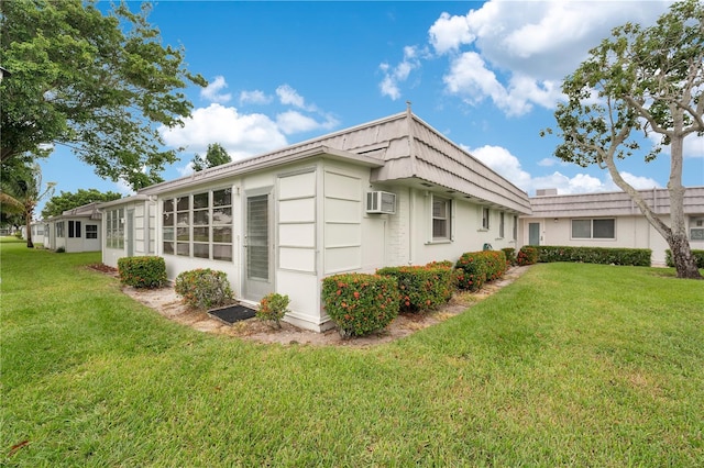 view of property exterior with a lawn and a wall mounted air conditioner