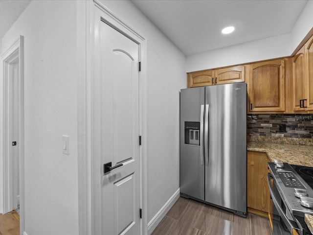 kitchen featuring decorative backsplash, stainless steel appliances, light stone countertops, and dark hardwood / wood-style floors