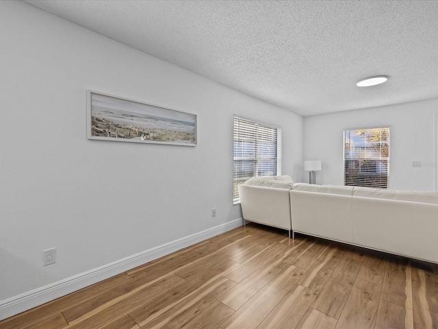 unfurnished living room featuring a textured ceiling and light hardwood / wood-style flooring