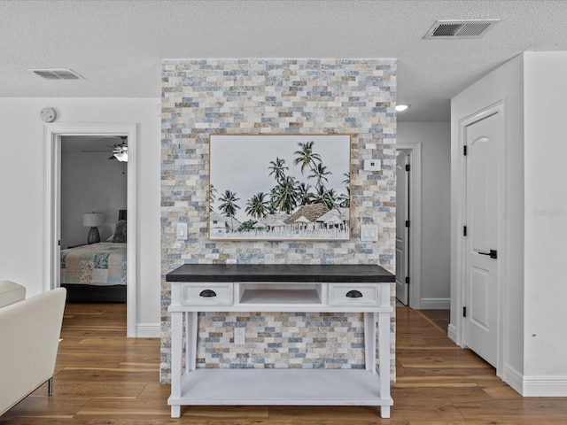 hall with a textured ceiling and hardwood / wood-style flooring