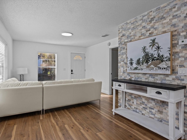 living room featuring a textured ceiling and dark hardwood / wood-style floors