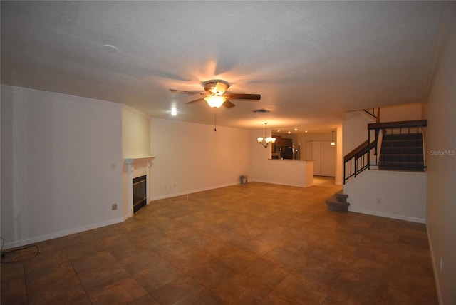 unfurnished living room featuring ceiling fan with notable chandelier