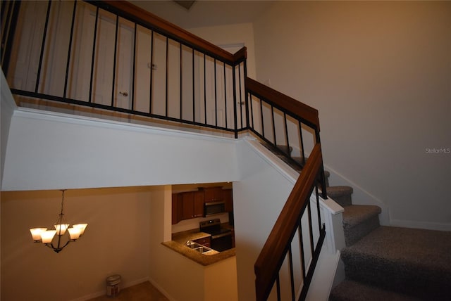 staircase with carpet and an inviting chandelier