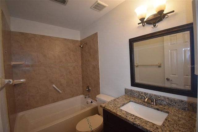 full bathroom with vanity, tiled shower / bath combo, and toilet