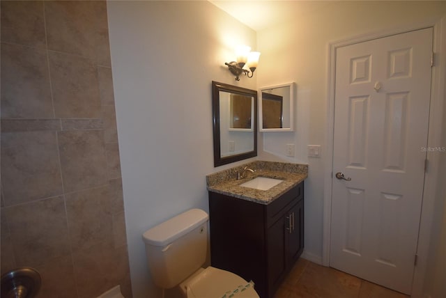 bathroom featuring tile patterned flooring, vanity, and toilet