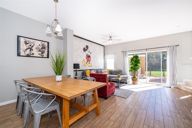 dining area with ceiling fan with notable chandelier and a healthy amount of sunlight