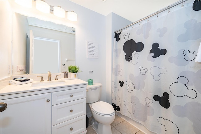 bathroom with tile patterned flooring, vanity, toilet, and walk in shower