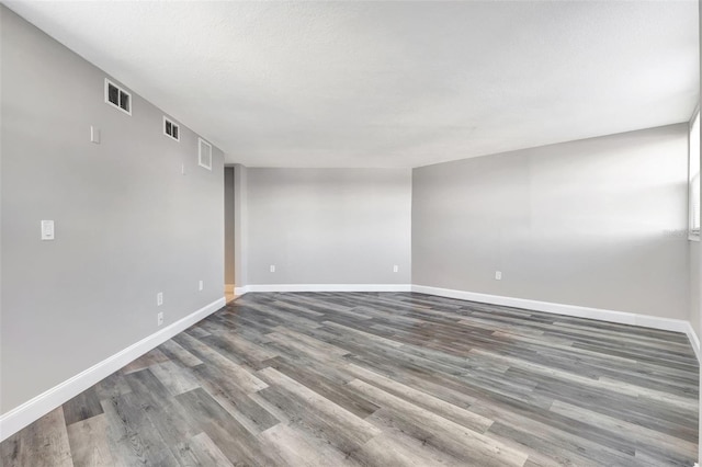 spare room featuring wood-type flooring and a textured ceiling