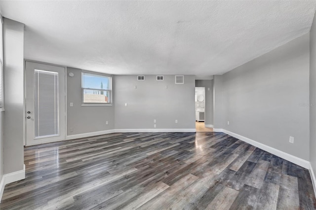 unfurnished room with dark hardwood / wood-style flooring and a textured ceiling