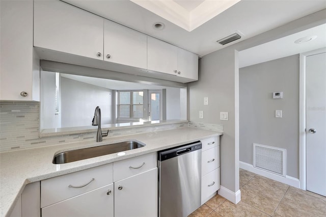 kitchen featuring backsplash, white cabinets, sink, stainless steel dishwasher, and light stone counters