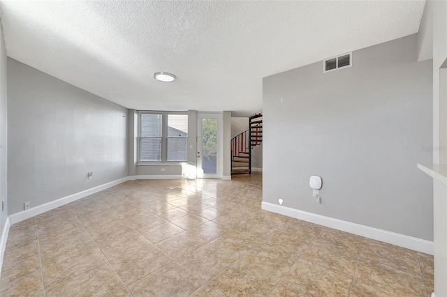 spare room with light tile patterned floors and a textured ceiling