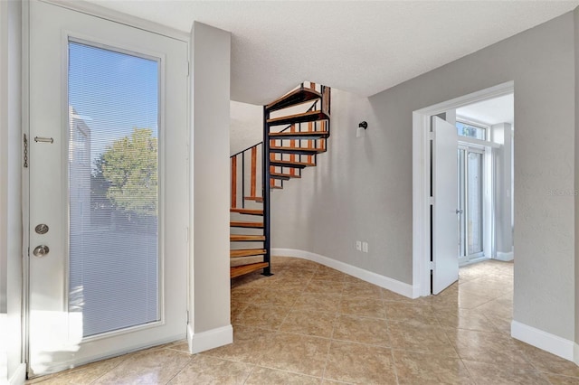 interior space with light tile patterned floors and a textured ceiling