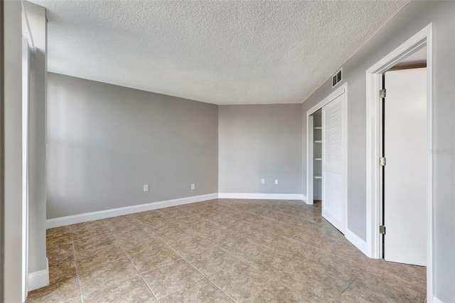 unfurnished room with a textured ceiling