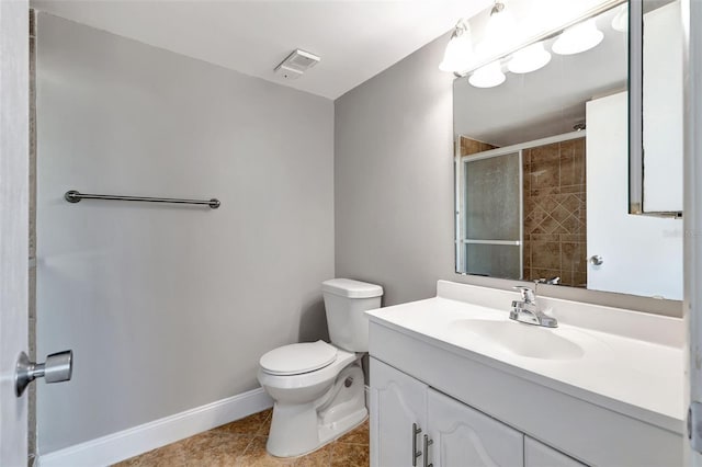 bathroom featuring tile patterned floors, vanity, a shower with shower door, and toilet