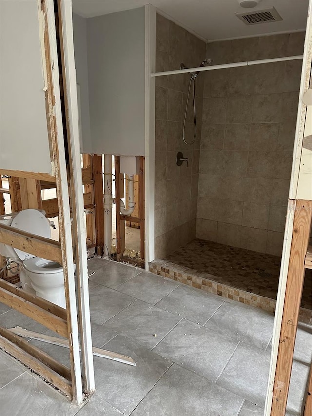 bathroom with toilet and tiled shower