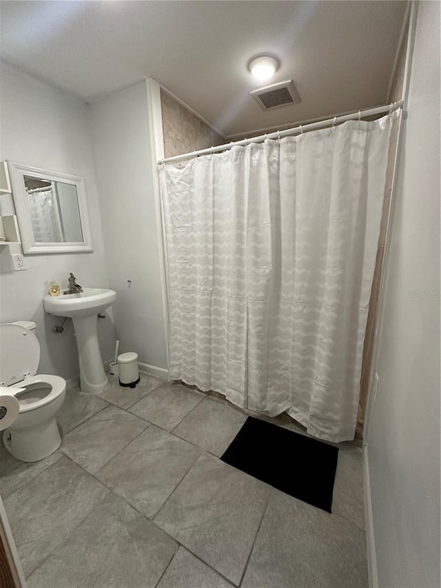 bathroom with toilet and a shower with curtain