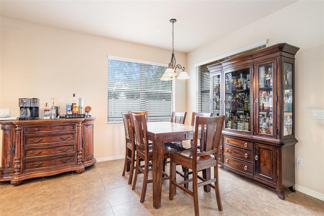 dining area with light tile patterned flooring and an inviting chandelier