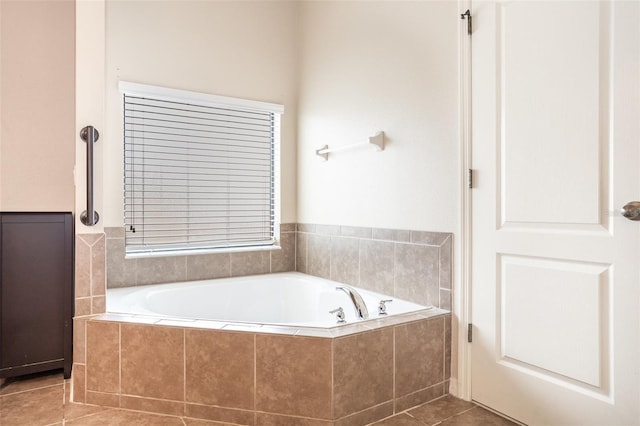 bathroom with tiled bath and tile patterned flooring