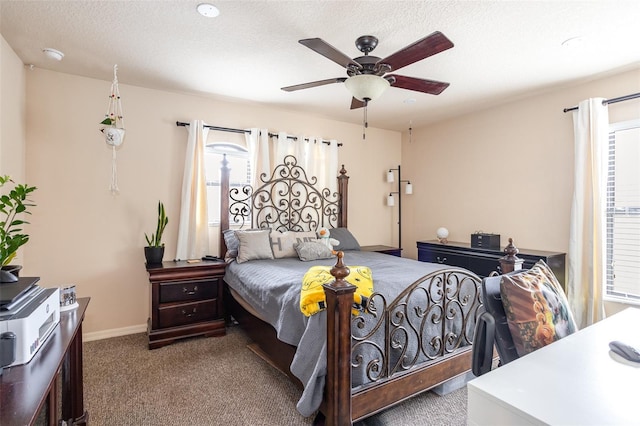 carpeted bedroom featuring ceiling fan and a textured ceiling