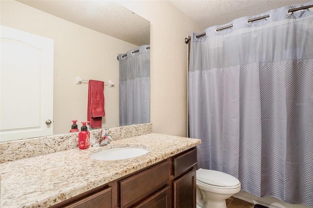 bathroom featuring a textured ceiling, toilet, and vanity