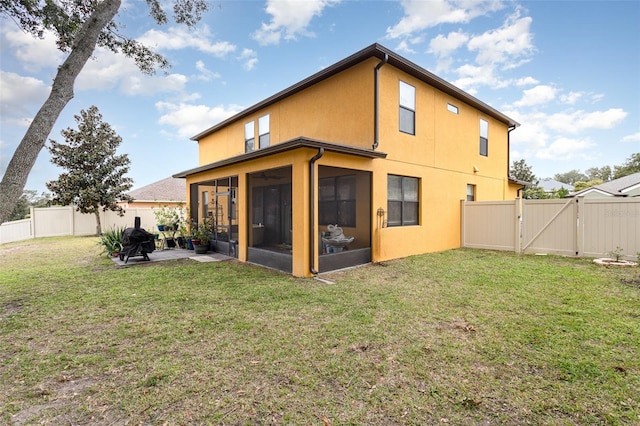 rear view of property featuring a sunroom, a yard, and a patio