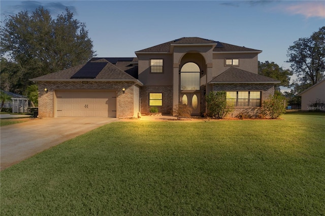 view of front facade featuring solar panels, a yard, and a garage