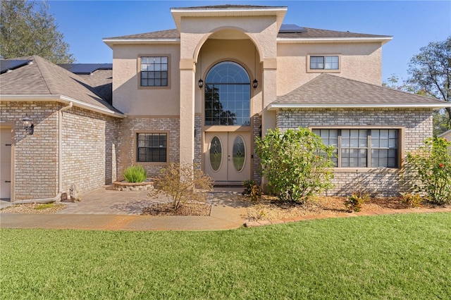 view of front of home featuring a patio area, a front yard, and solar panels