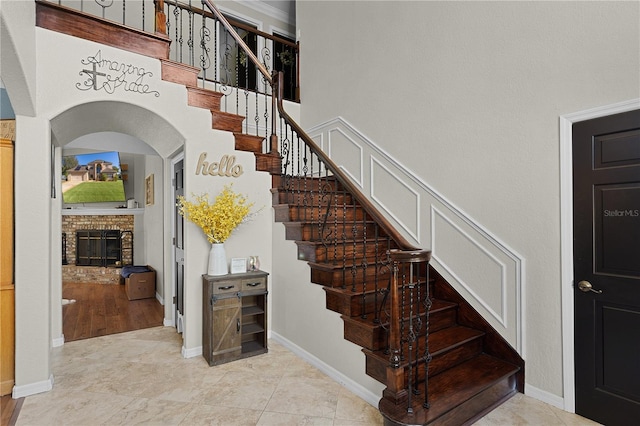 staircase featuring tile patterned flooring and a fireplace