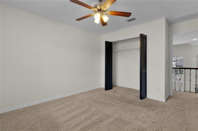 unfurnished bedroom with a closet, light colored carpet, and ceiling fan