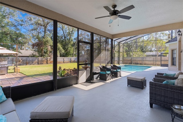 sunroom with ceiling fan and a pool