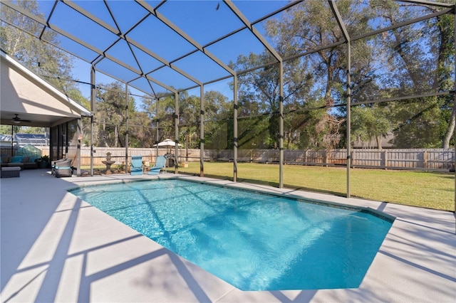 view of pool with a lawn, a patio area, and a lanai